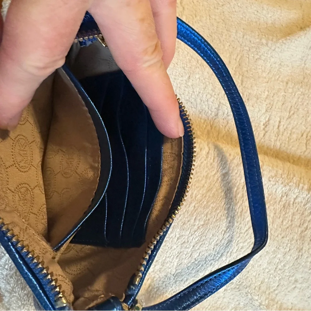 Michael Kors sapphire blue sequined wristlet with gold colored hardware.